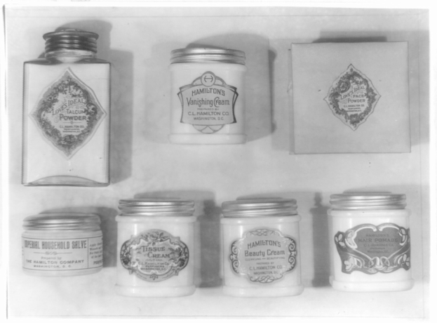 Schwarzes und weißes Foto eines Regals mit ordentlich angeordneten Cremetöpfen, die jeweils mit verschiedenen Arten beschriftet sind.