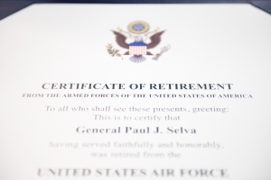 Rahmenurkunde zur Verabschiedung aus der US-Luftwaffe mit blauem Rand, zentrales Schild-Logo mit einem Stern, Lorbeerkranz und Banner "Verabschiedung" in schwarzer Tinte.