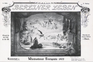 Ein Schwarz-Weiß-Foto einer Bühne der Wiesbadener Festspiele aus dem Jahr 1902, das Menschen in traditioneller deutscher Tracht zeigt, einige mit Hüten und andere mit Umhängen, unter bunten Lichtern und Dekorationen, während das Publikum im Hintergrund jubelt und klatscht.