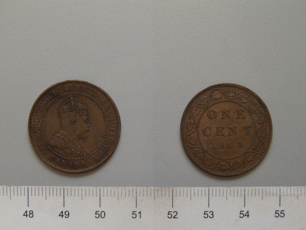 Zwei Ein-Cent-Münzen nebeneinander auf einem Lineal auf einer weißen Oberfläche.