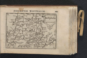 Ein aufgeschlagenes Buch, das eine detaillierte Karte der geografischen Merkmale Westphalens auf einer schwarzen Oberfläche zeigt.