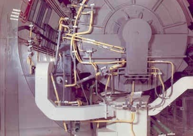 Großes industrielles Beschleunigergerät mit mehreren verbundenen Komponenten und Drähten innerhalb eines Gebäudes.