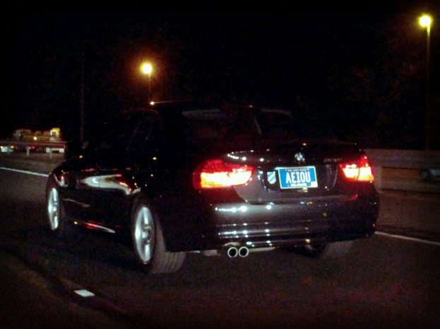 Ein schwarzes Auto mit Lichtern und einer Aufschrift steht in der Mitte einer Stra├če, mit einem schwarzen Hintergrund mit Lichtern.