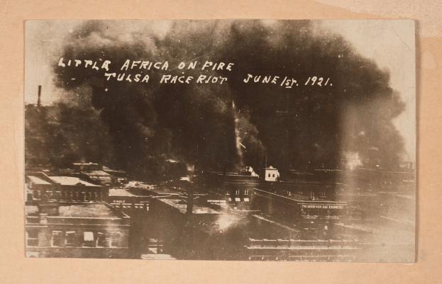 Schwarzes und weißes Foto einer Stadt mit Rauch, das Text in der Mitte und Gebäude unten enthält.