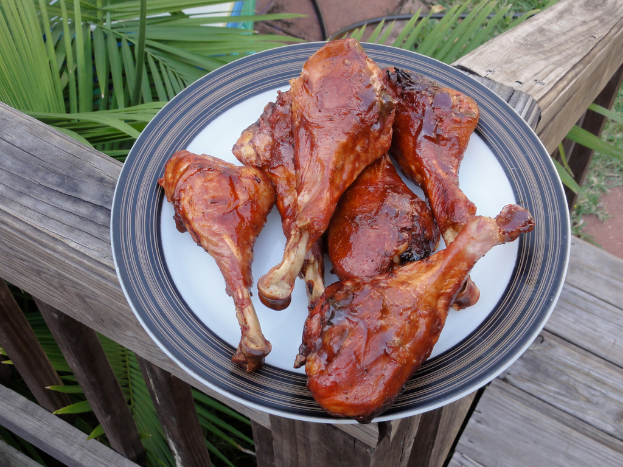 Ein Teller mit Fleisch darauf wird auf einem hölzernen Zaun mit Bäumen im Hintergrund platziert.