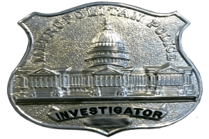 Ein silbernes Polizeibadgebnis mit der Aufschrift "Investigator" vor einem weißen Hintergrund.