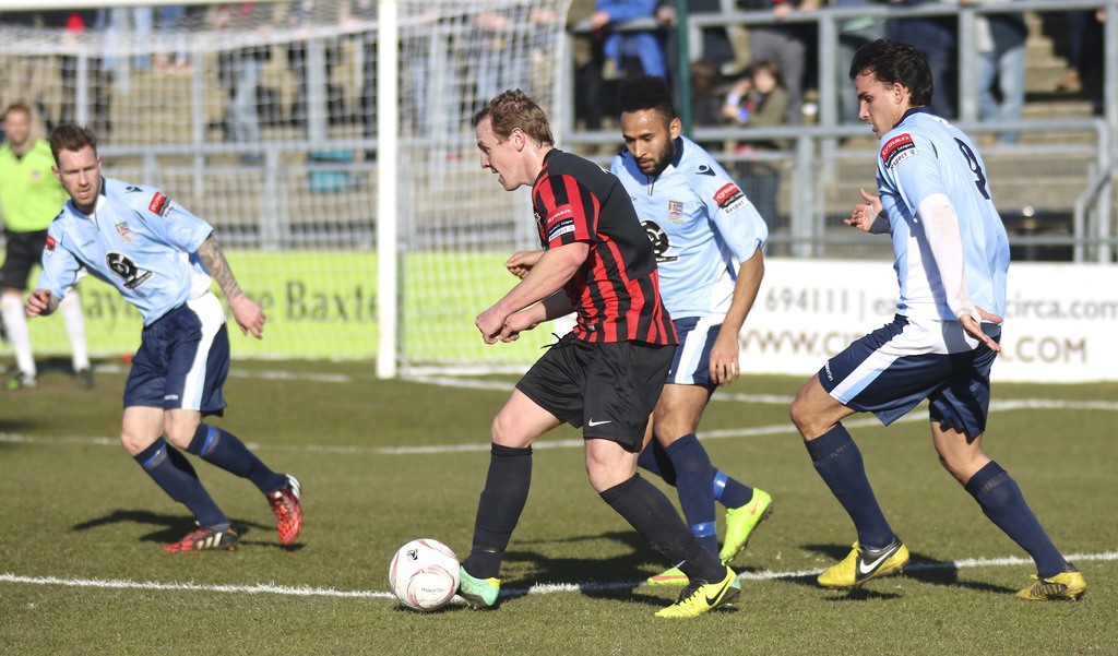 Eine Gruppe von Menschen, die mit einem Fußball auf einem Feld spielt.