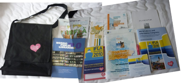 Eine Tasche mit "Bibliotheksliebhaber" drauf und einige Bücher liegen auf einem Bett.