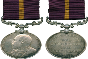 Silberne Medaille mit einem violetten und gelben Band, das eine linksseitige Porträtaufnahme und eine rechtsseitige Inschrift mit der Aufschrift 'Langjähriger treuer Dienst' zeigt.