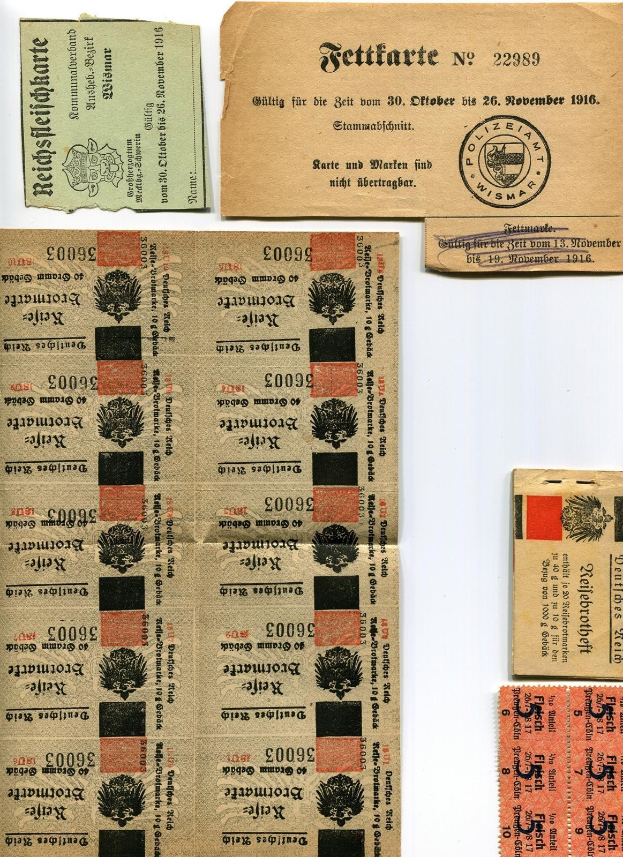 Sammlung alter deutscher Tickets und Marken auf einem weißen Hintergrund, mit abgegriffenem Papier und gedrucktem Text und Zahlen.