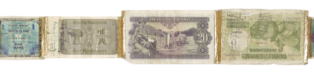 Ein altes Buch mit verschiedenen Scheinen alter deutscher Banknoten darauf gestapelt.