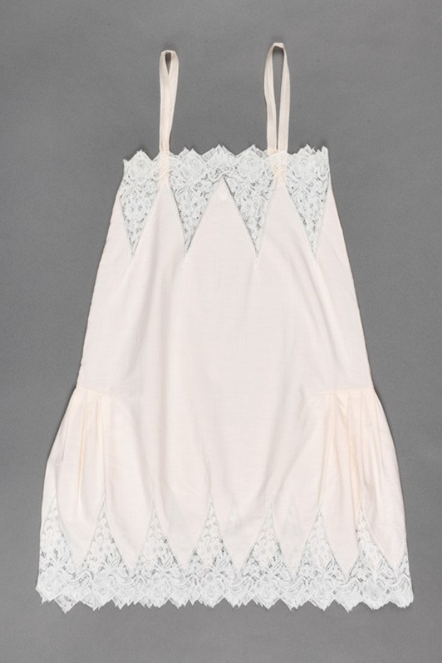 Weißes Slipkleid mit zartem Spitzenbesatz am Saum, aus leichtem, luftigem Stoff, mit femininer Form für besondere Anlässe.