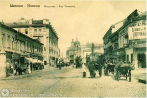 Altes Schwarz-Weiß-Foto einer Moskauer Stadtstraße mit Passanten, Pferdewagen, Gebäuden, Schildern, Laternen und Text oben und unten.