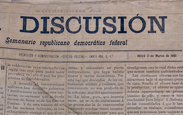 Eine gelbliche, leicht zerknitterte Zeitung mit der schwarzen Aufschrift 'Diskussion', die die Schlagzeile 'Semanario Repúblicano Democrático Federal' trägt.
