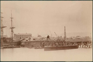 Eine Szene mit Wasser, Booten, Geb├Ąuden, Strommasten und Himmel.