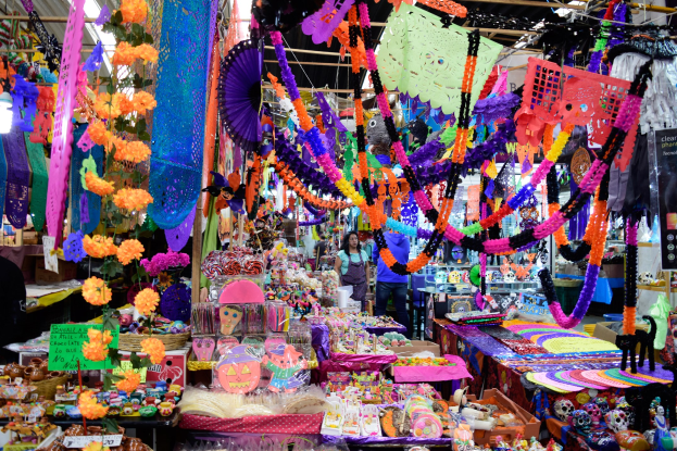 Ein belebter Markt mit Menschen, Spielzeugen, Dekorationsgegenständen und anderen Verkaufsgegenständen unter Deckenbeleuchtung.