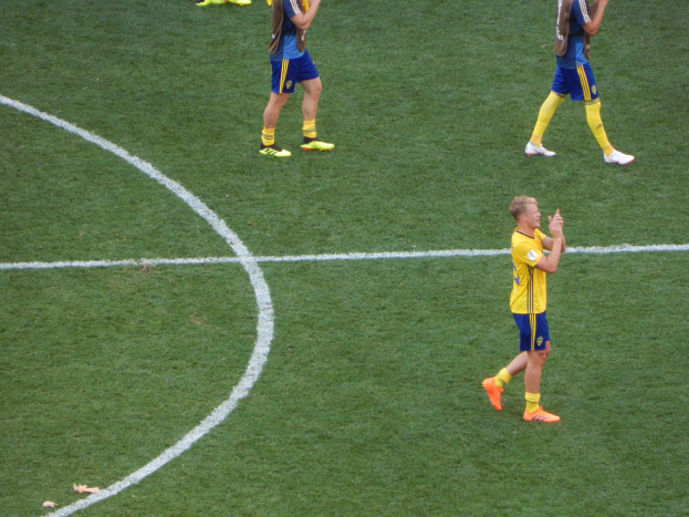 Mannergruppe in Fußballtrikots klatscht auf einem Feld, feiert ein Spiel.