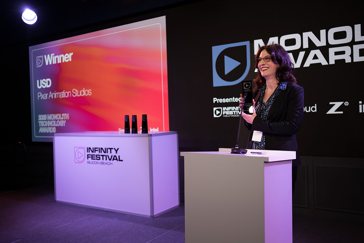 Frau in einem schwarzen Kleid, die eine Auszeichnung hält und vor einem Podium mit einem Mikrofon steht, während der Monolux Awards 2020.