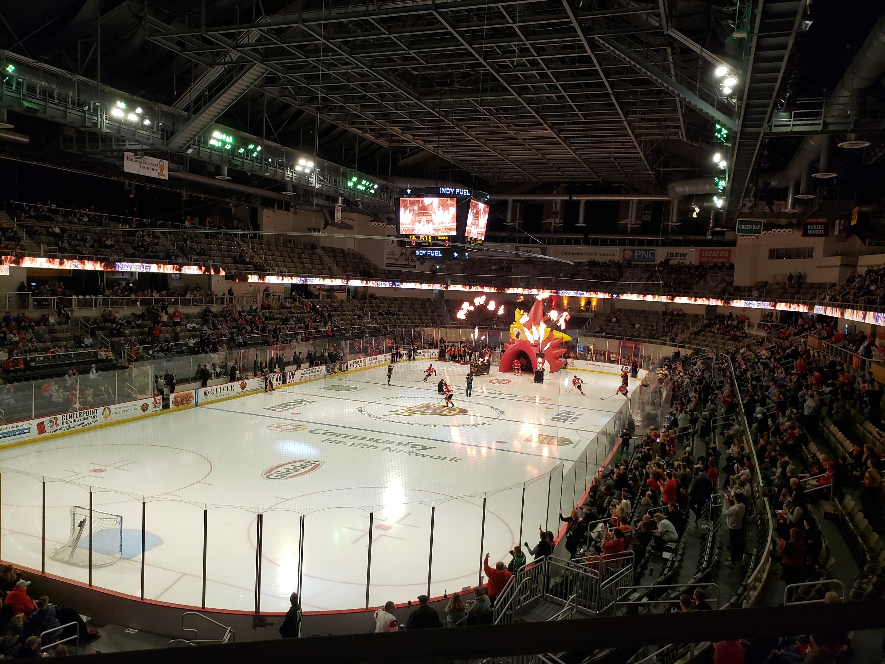Eishockeyspiel in einer großen Arena mit Sitzplätzen und Stehplätzen, umgeben von einer Bande, Bannern, Überdachung, Metallstangen, Lampen und Bildschirmen, identifiziert als Nationwide Arena.