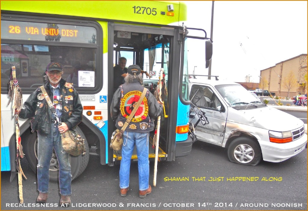 Eine Person in einer schwarzen Jacke hält eine Tasche und einen Stock, steht auf einer Straße in der Nähe eines Busses mit einer anderen Person, die einen Stock und eine Tasche hält; im Hintergrund sitzt eine Person im Bus, ein beschädigtetes Fahrzeug befindet sich auf der Straße und es gibt Gebäude, Fahrzeuge, Pflanzen, einen Baum und den Himmel.