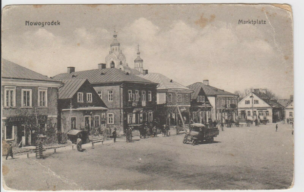 Schwarzes und weißes Foto einer Stadtstraße in Nowogrodziec, Deutschland, mit Gebäuden, Menschen, Karren, Pfählen, Bäumen und Himmel, mit dem Text "Marktplatz in Nowogrodeek, Deutschland" oben und unten.