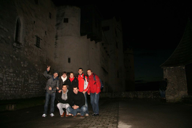 Menschen, die in einer nächtlichen Szene in der Mitte stehen, mit einem Schloss im Hintergrund.