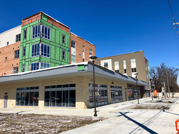 Großes mehrstöckiges Gebäude mit zahlreichen Fenstern, Teil des Campus der University of Wisconsin-Madison, umgeben von Straßeninfrastruktur und Fahrzeugen, mit Bäumen und einem bewölkten Himmel im Hintergrund.