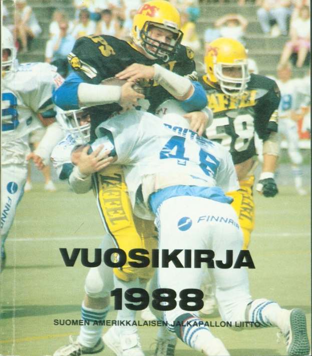 Gruppe von Menschen in Sportbekleidung und Helmen, die American Football auf einem Feld spielen, mit Zuschauern auf einer Treppe im Hintergrund; Text unten lautet "Vuosikirja 1988 - Suomen Amerikkaisen Jalkapallon Litto".